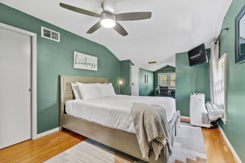 Cozy bedroom with sage green walls, a modern bed, and a serene atmosphere.