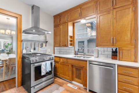 Modern kitchen with wooden cabinetry, stainless steel appliances, and bright natural light.