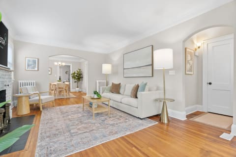 Living room featuring a light beige sofa, wooden flooring, and modern decor.