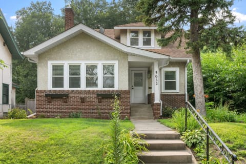 Front view of a single-family home with landscaped yard and a welcoming porch.