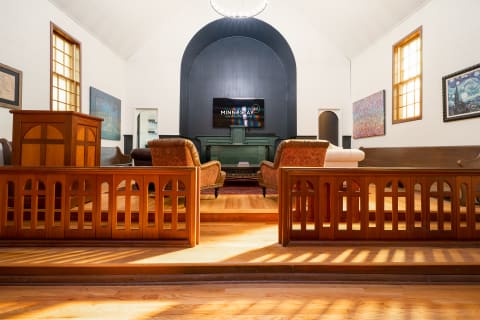 Interior space with wooden elements and seating, illuminated by natural light.