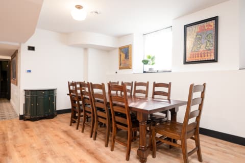 A dining area featuring a long wooden table and chairs, with decorations and a window allowing natural light.