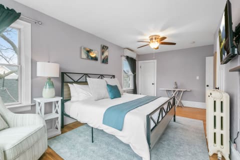 A cozy bedroom with a metal bed frame, light linens, and turquoise accents.