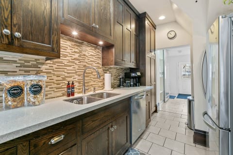 Interior view of a modern kitchen with dark wood cabinets, a granite countertop, and stainless appliances.
