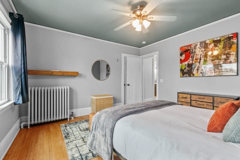 Stylish bedroom with a comfortable bed, abstract art, and wooden accents.