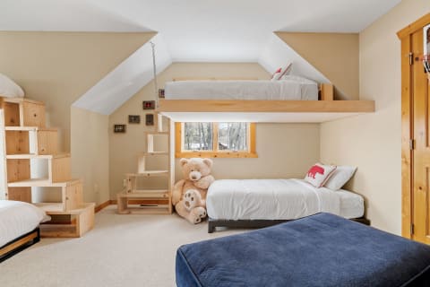 Cozy children's bedroom featuring a lofted bed and plush toys.