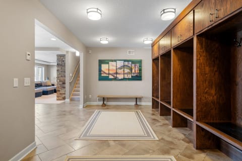 Spacious entryway featuring wooden lockers, artwork, and tiled flooring.