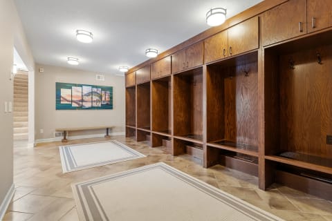 Spacious entryway with wooden lockers and vibrant landscape artwork.