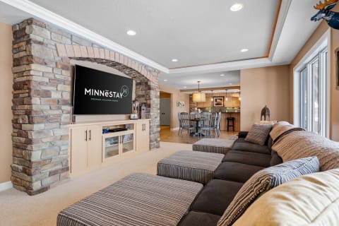 Contemporary living room with a stone archway, large TV, and sectional sofa.
