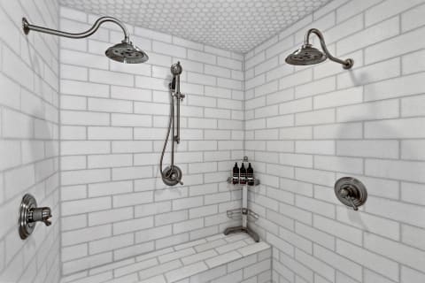 Modern shower with white subway tiles, chrome fixtures, and a built-in bench.
