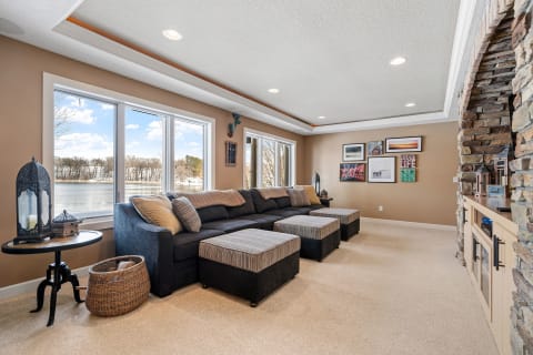 Cozy living room featuring a sectional sofa, lake view windows, and decorative artwork.