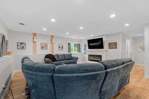 A modern living room featuring a blue sectional sofa, fireplace, and wall art.