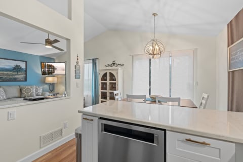 A view of an open-concept kitchen and living area featuring a stylish design and natural light.