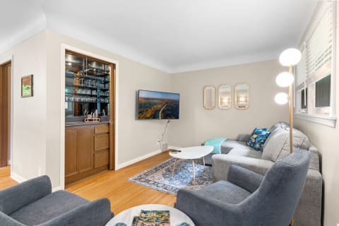 Cozy living room with gray sofa, armchairs, and a stylish bar area.