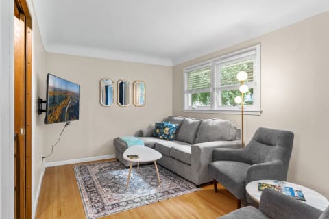A cozy living room with a gray sectional sofa, coffee table, and modern lighting fixtures.