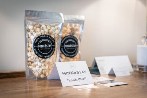 Complimentary popcorn bags and a thank-you card from Minnēstay on a wooden surface.