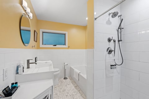 Contemporary bathroom with yellow walls, white tiles, and modern fixtures.