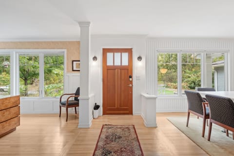 Interior view of a cozy home entryway with a wooden door and stylish furnishings.