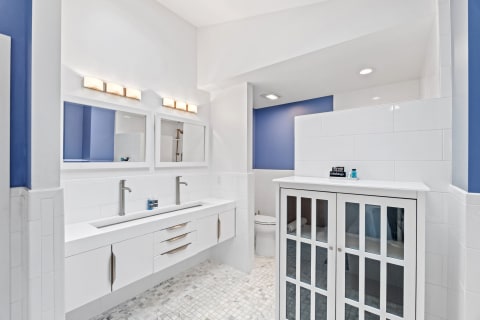 Modern bathroom featuring a double sink and blue walls.