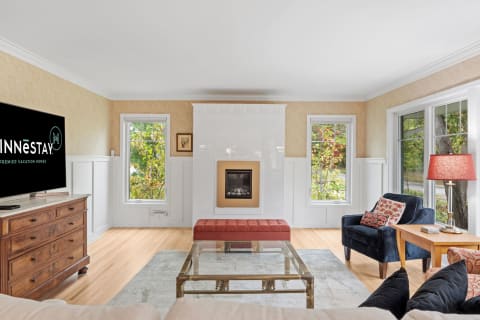 A stylish living room featuring hardwood floors, a modern fireplace, and comfortable seating.
