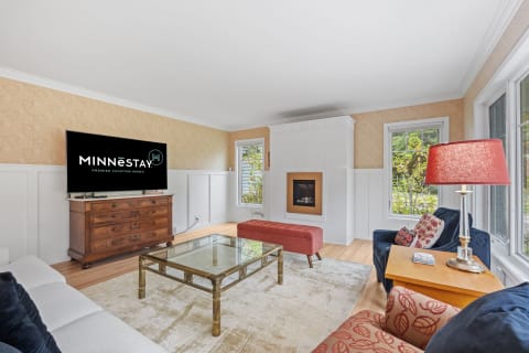 Modern living room with flat-screen TV, glass coffee table, and comfortable seating.