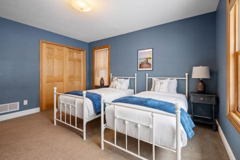 Cozy twin bedroom with blue walls and white bedding