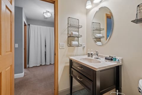 Interior of a cozy bathroom with a dark wooden vanity and white towels on display.
