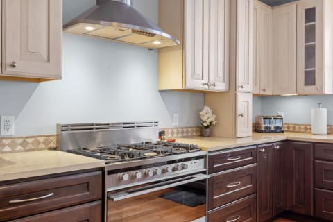 Interior view of a modern kitchen with a gas stove and contrasting cabinets.