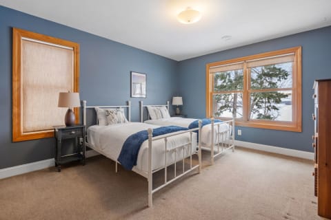 Cozy twin bedroom with blue walls and wooden trim.