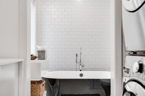 A contemporary bathroom with white subway tiles, a sleek bathtub, and modern fixtures.
