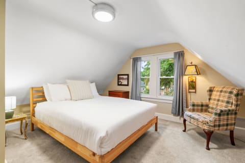 Cozy attic bedroom with sloped ceiling and elegant decor.