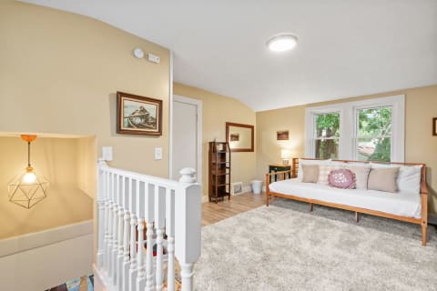 Cozy room featuring a wooden bench, bright windows, and decorative elements.