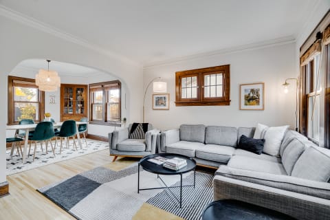 Living room with a gray sectional couch, black coffee table, and a teal dining set.