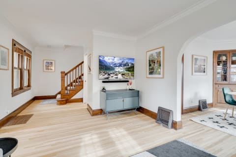 Living room featuring hardwood floors, a modern TV, and artistic decor.