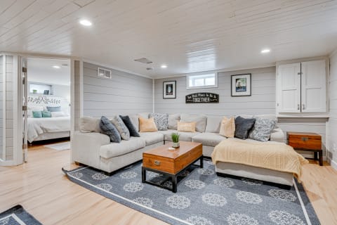 Cozy basement living room featuring a sectional sofa, coffee table, and decorative wall art.