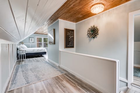 Cozy hallway with wooden ceiling leading to a bedroom.