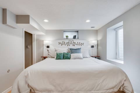 A modern bedroom featuring a large bed with decorative pillows and a stylish headboard.
