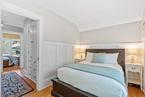 Cozy bedroom featuring a queen-sized bed, soft blue accents, and warm lighting.