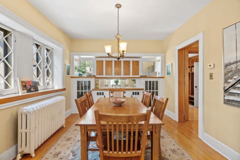 A cozy dining room with a wooden table and diamond-patterned windows.