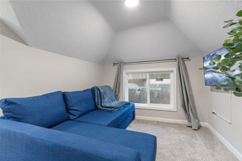 Small living area with blue sectional sofa and window.
