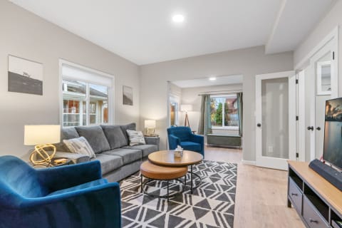 Cozy living room with gray sofa, blue armchairs, and a wooden coffee table.