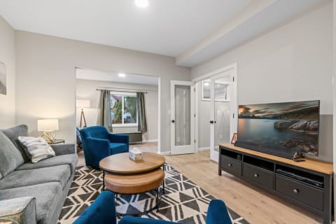 A cozy living room with a gray sofa, turquoise chairs, and a wooden coffee table.