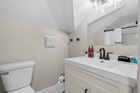 Stylish bathroom with a white toilet, modern sink, and under-sink storage.