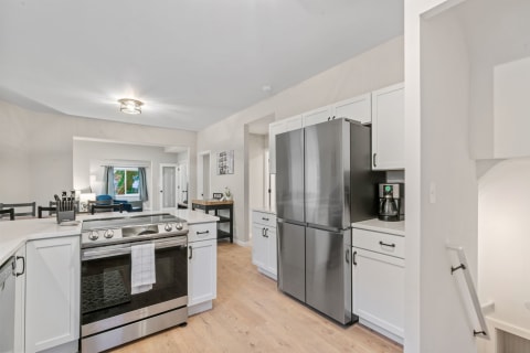A contemporary kitchen with a spacious design featuring stainless steel appliances and bright cabinetry.