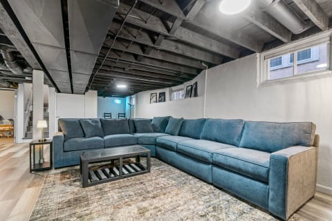 Interior view of a basement living room featuring a blue sectional sofa and modern decor.