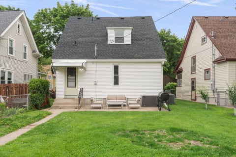 Exterior view of a two-story house with a patio and garden.
