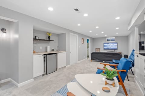 Spacious lower-level suite with kitchenette, seating area, and entertainment setup.