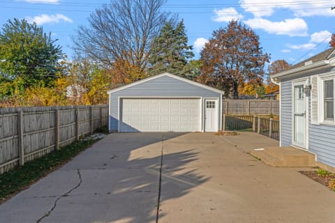 Two-car garage with a white door set against a fall backdrop.