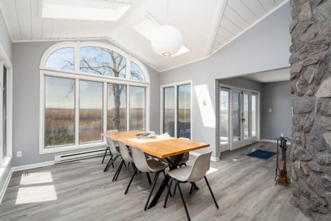 Bright dining room with large windows and a wooden table.