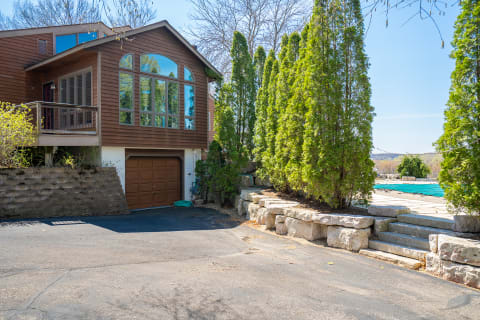 Exterior view of a contemporary house with a garage and green conifers.